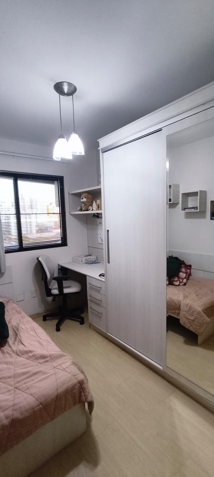 Quarto com guarda-roupa espelhado e escrivaninha